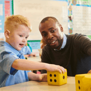 A male teacher talking to a primary school male student